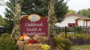 Close up of outdoor sign with fall decorations in frint of it.JPG