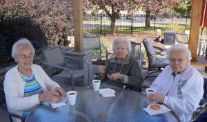Residents eating cookies around patio table
